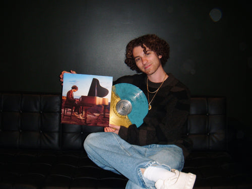 Brandon Rosen Holding his split color Vinyl for his debut album "Hourglass"